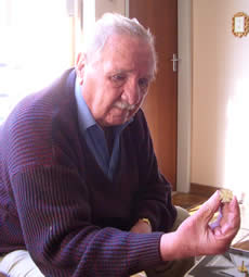 Mr Victor Burger holding up his miniture Burgers Cross, made from the last gold mined at Pilgrims Rest